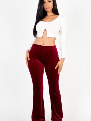 A woman wearing a short top and velvet pants